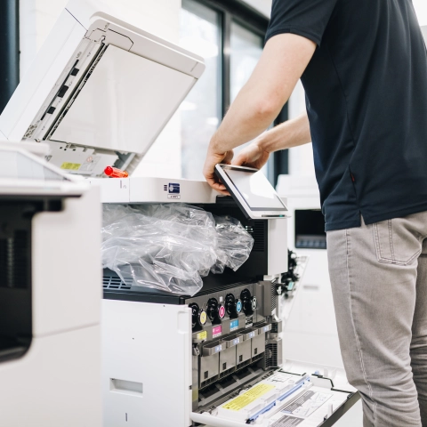 Installateur installeert een touchscreen scherm aan een printer.