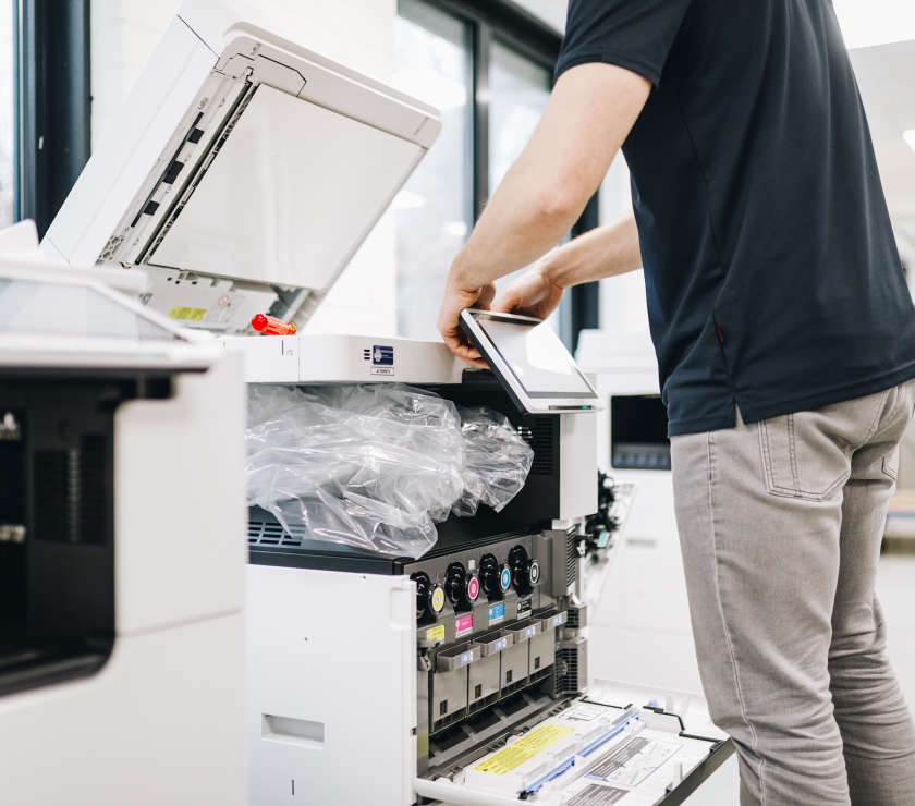 Installateur installeert een touchscreen scherm aan een printer.