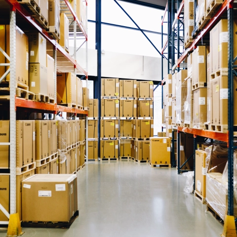 Tientallen verpakte printers uitgestald in een magazijn.