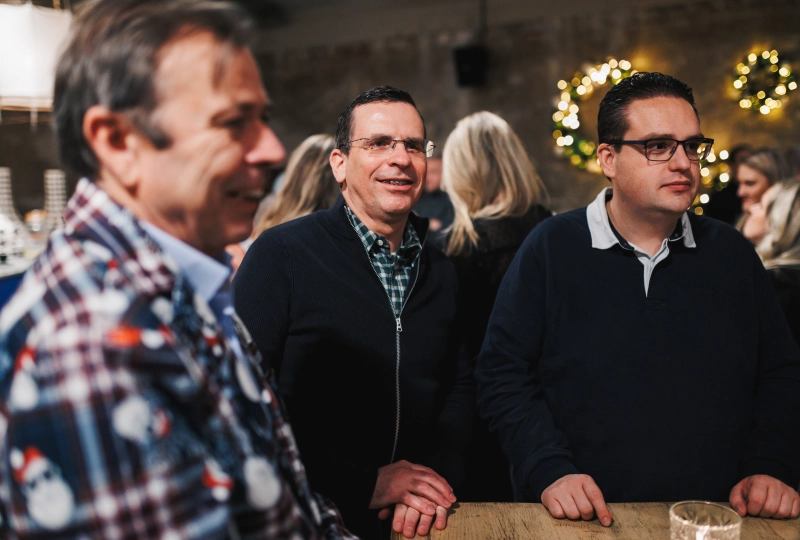 Meerdere personen die aanwezig zijn op een bedrijfsfeest, waaronder de persoon waar een artikel over is geschreven.