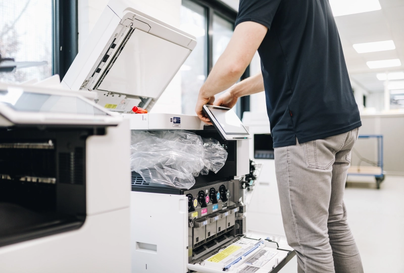Installateur installeert een touchscreen scherm aan een printer.