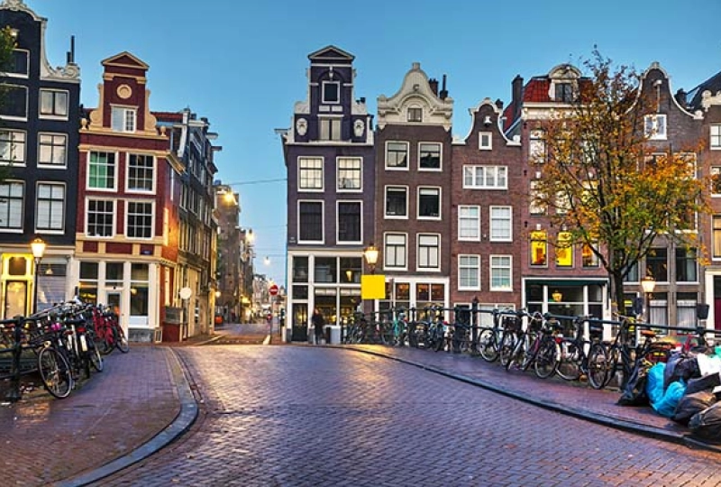 Een straat van de Jordaan in Amsterdam waar de zon net ondergaat en zorgt voor een gezellige uitstraling.