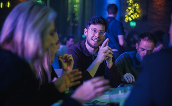 Collega Gijs aan tafel op de Nou kerstviering
