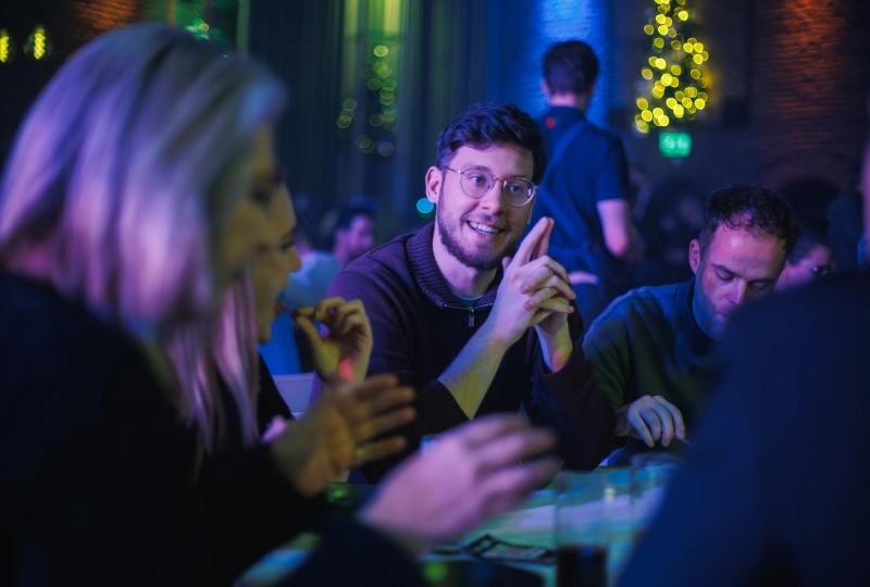 Collega Gijs aan tafel op de Nou kerstviering