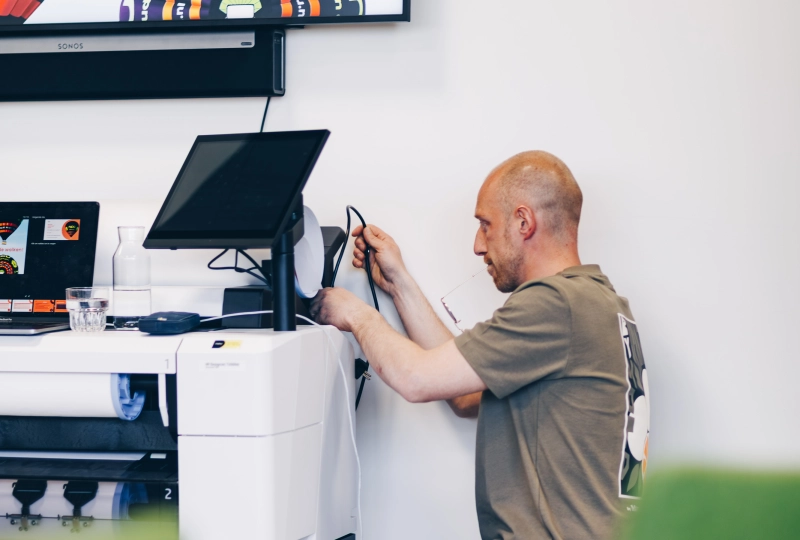 Nou medewerker bezig met snoertjes en computer