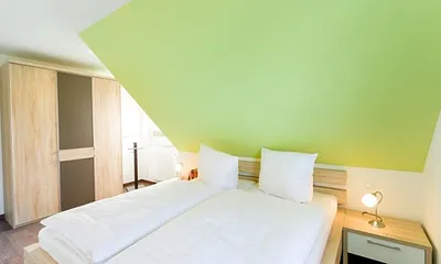 Schlafzimmer mit Doppelbett und Kleiderschrank