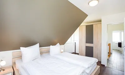 Schlafzimmer mit Doppelbett und Kleiderschrank