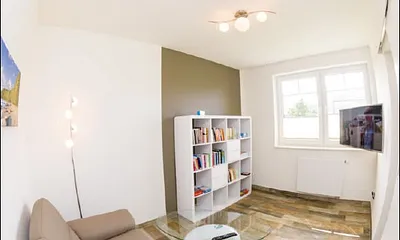 zweiter Wohnbereich mit Couch, TV und Auswahl an Büchern und Spielen