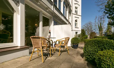 Ihre möblierte Terrasse schaut nach Osten. Rechts im Bildhintergrund sehen Sie die Strandpromenade.