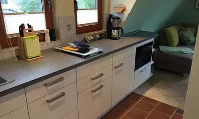 Küchenzeile mit Herd, Kühlschrank, Mikrowelle und Geschirrspüler