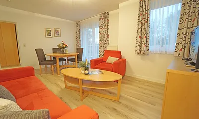 Wohnzimmer mit Esstisch und Flachbildfernseher