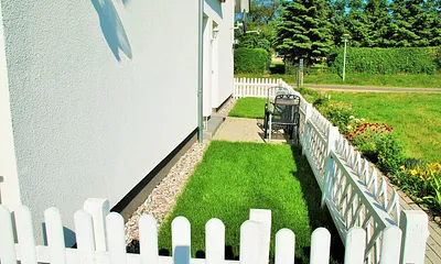 Eingezäunter Vorgarten mit kleiner Terrasse