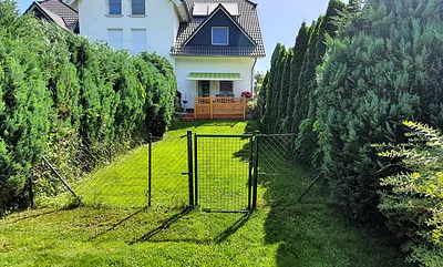 Blick auf den umzäunten Rasen mit Terrasse