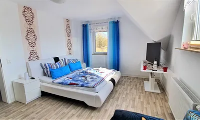 Schlafzimmer mit großem Doppelbett und zusätzlich ausklappbarer Schlafcouch