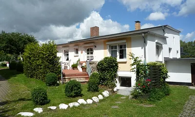 Die weiße Steinreihe läuft auf Ihre möblierte Terrasse rechts unten am Haus zu. 