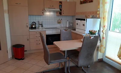 offene Küche mit Essplatz und Geschirrspüler, Toaster, Kaffeemaschine, Wasserkocher