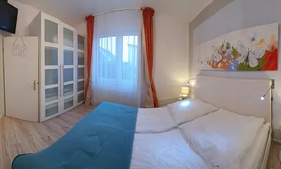 Schlafzimmer mit einem  Doppelbett, Kleiderschrank und einem TV