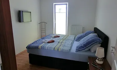 Schlafzimmer mit Doppelbett und SAT-TV