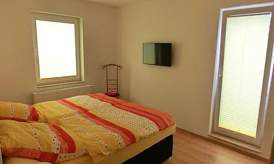 Schlafzimmer mit Doppelbett und SAT-TV