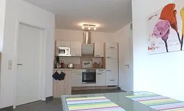 Blick vom Esstisch zur voll ausgestatteten Küchenzeile