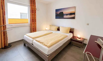 Schlafzimmer mit Doppelbett und zweitem Fernseher