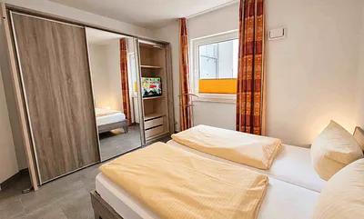 Schlafzimmer mit Doppelbett und zweitem Fernseher