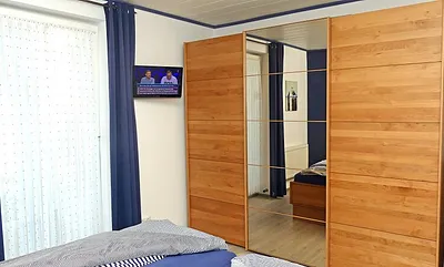 Im Schlafzimmer finden Sie außerdem einen LCD-Fernseher und einen sehr geräumigen Kleiderschrank mit Ganzkörperspiegel, Zugang zum Innenhof über Kipptür
