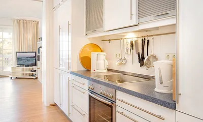 Die Küche ist vom Wohnzimmer durch eine Schiebetür getrennt.