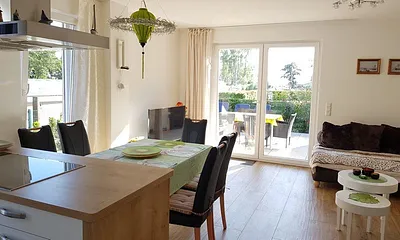 Heller Wohn- und Essbereich mit hochwertiger Küche. Die offene Küche ist komplett ausgestattet.