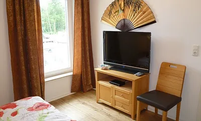 1. Schlafzimmer mit Massivholz-Doppelbett (Breite 1,60 m) und Fernseher.