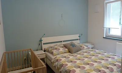 Schlafzimmer 2 mit Gitterbett Wohnung 2