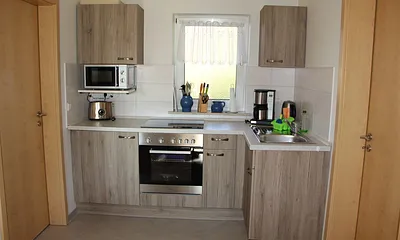 Küche mit Herd, Mikrowelle, Kaffeemaschine, Wasserkocher und Toaster