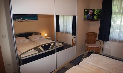 Schlafzimmer mit Spiegelschrank und TV-Gerät