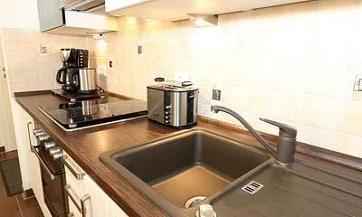 integrierte Küchenzeile mit Mikrowelle, Backofen, Ceranfeld, Spülmaschine, Kühlschrank mit Gefrierfach, Kaffeemaschine und anderen praktischen Hilfsutensilien