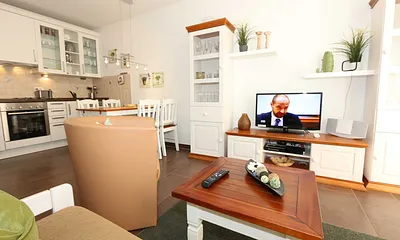 Wohnbereich mit Essecke, gemütlicher Couch (1,60 m x 2,00 m), Couchtisch, Stehlampe, 2 Vitrinen, Sideboard mit LCD-TV, DVD-Player und Musikanlage vorhanden
