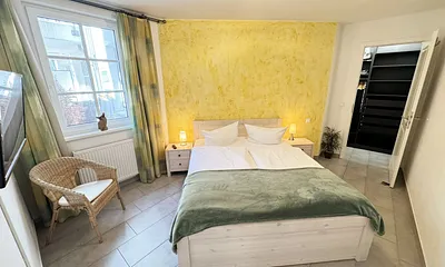 Schlafzimmer mit Doppelbett (1,60 m x 2,00 m), kleiner Flachbildschirm, Nachttischkonsolen, begehbarem Kleiderschrank und Insektenschutzgitter