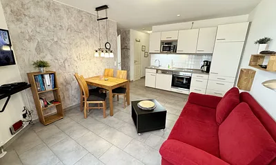 Wohnbereich mit einer Essecke, gemütlicher Couch (Aufbettung für 3./4. Person 1,60 m x 2,00 m), Smart-TV,Blu-Ray-Player und Musikanlage mit DAB Radio