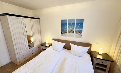 Schlafzimmer mit Doppelbett und Kleiderschrank