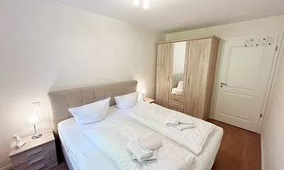 Schlafzimmer mit einem Boxspringbett (1,80 m x 2,00 m), Ablagefläche, Kleiderschrank und Insektenschutzgitter