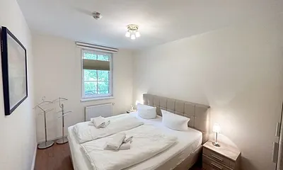 Schlafzimmer mit einem Boxspringbett (1,80 m x 2,00 m), Ablagefläche, Kleiderschrank und Insektenschutzgitter