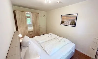 Schlafzimmer mit einem Boxspringbett (1,80 m x 2,00 m), Ablagefläche, Kleiderschrank und Insektenschutzgitter