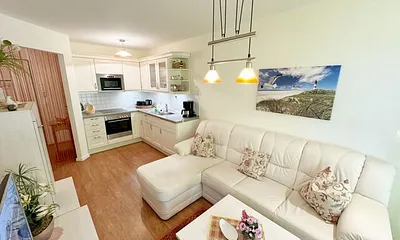 Wohnbereich mit gemütlicher Couch, Leselampe, Smart-TV, DVD-Player und Radio mit CD