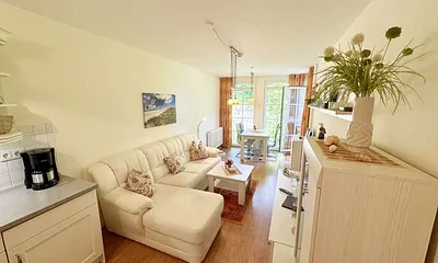 Wohnbereich mit gemütlicher Couch, Leselampe, Smart-TV, DVD-Player und Radio mit CD