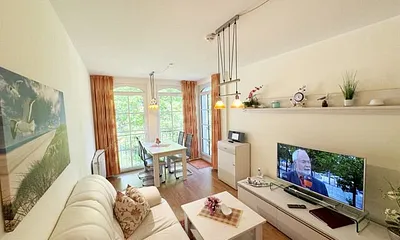 Wohnbereich mit gemütlicher Couch, Leselampe, Smart-TV, DVD-Player und Radio mit CD