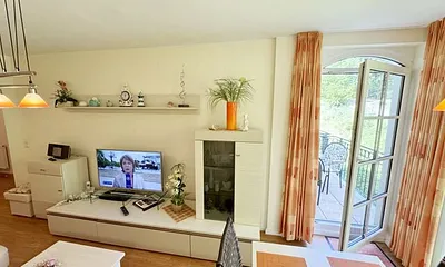 Wohnbereich mit gemütlicher Couch, Leselampe, Smart-TV, DVD-Player und Radio mit CD