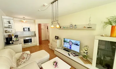 Wohnbereich mit gemütlicher Couch, Leselampe, Smart-TV, DVD-Player und Radio mit CD