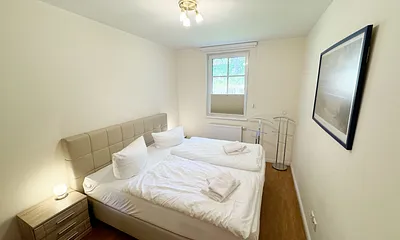 Schlafzimmer mit einem Boxspringbett (1,80 m x 2,00 m), Ablagefläche, Kleiderschrank und Insektenschutzgitter