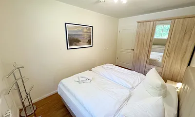 Schlafzimmer mit einem Boxspringbett (1,80 m x 2,00 m), Ablagefläche, Kleiderschrank und Insektenschutzgitter