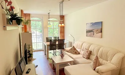 Wohnbereich mit gemütlicher Couch, Leselampe, Smart-TV, DVD-Player und Radio mit CD