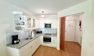 Küchenzeile mit Mikrowelle, Backofen, Ceranfeld, Spülmaschine, Kühlschrank mit Gefrierfach, Kaffeemaschine und praktischen Helfern